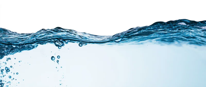 Close-up of water surface with ripples and bubbles against white background
