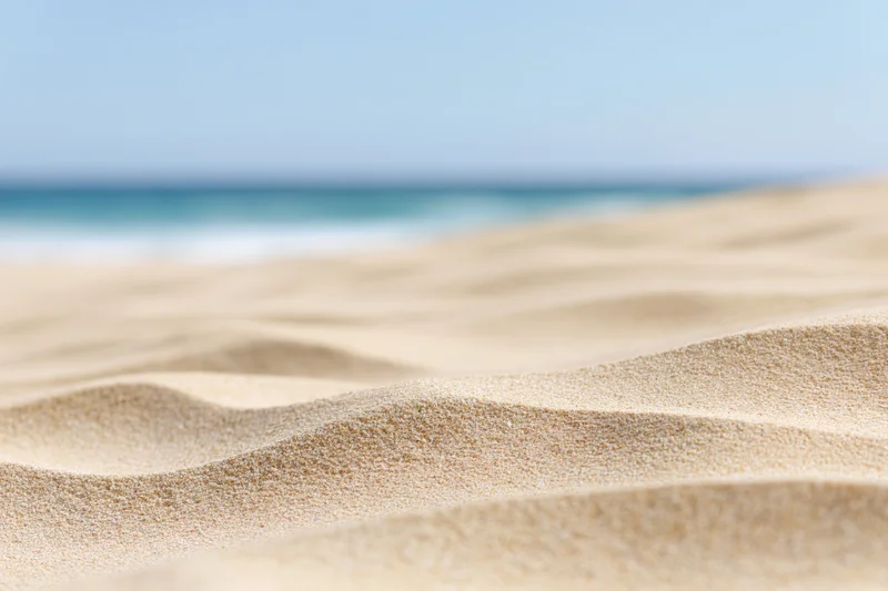 Closeup of rippled dry sand on a beach with ocean in the background