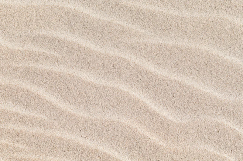 Close-up overhead view of rippled dry beach sand surface