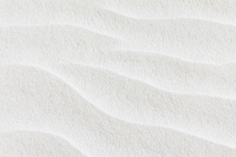 Close-up overhead view of fine white beach sand with rippled texture