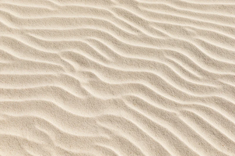 Close-up overhead view of rippled dry beach sand surface