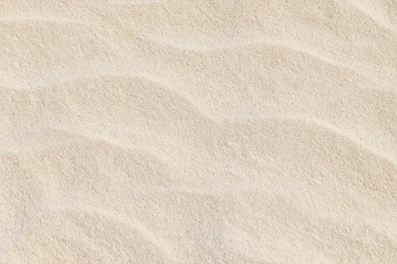 Close-up overhead view of dry beach sand surface with rippled texture