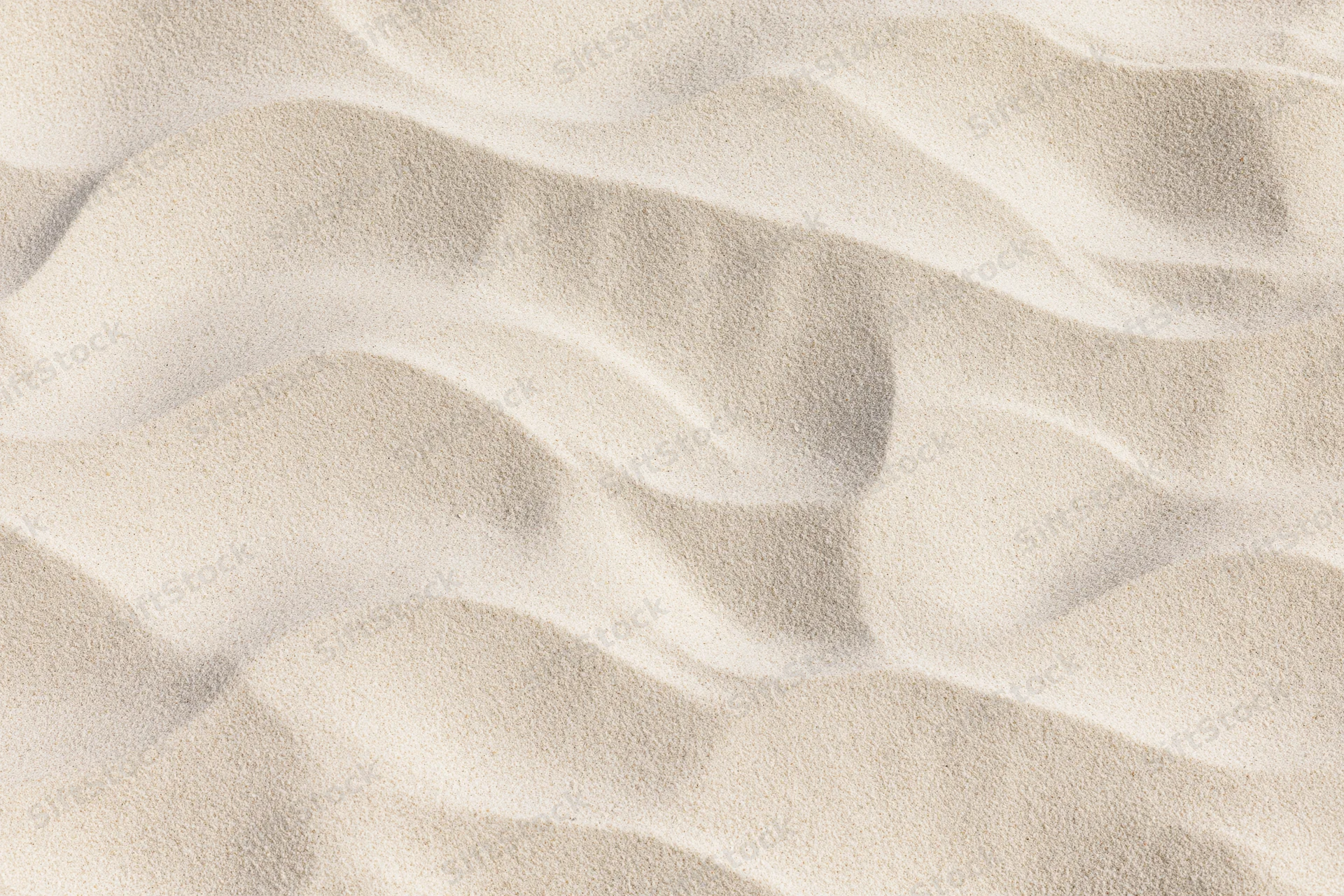 Close-up overhead view of rippled dry beach sand surface
