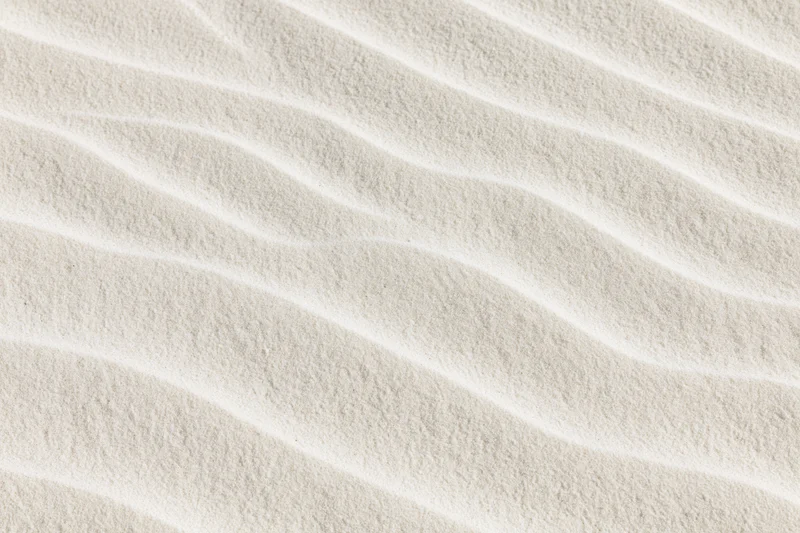 Close-up overhead view of rippled dry beach sand surface