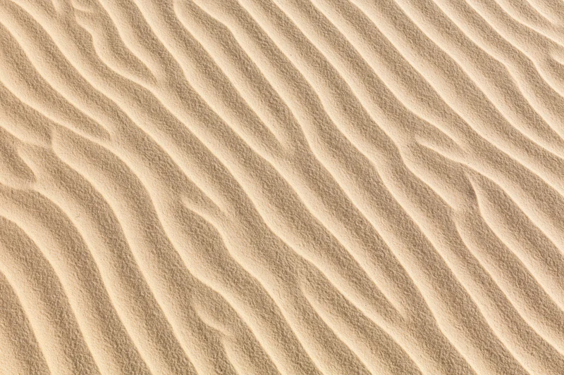 Close-up overhead view of rippled dry desert sand surface
