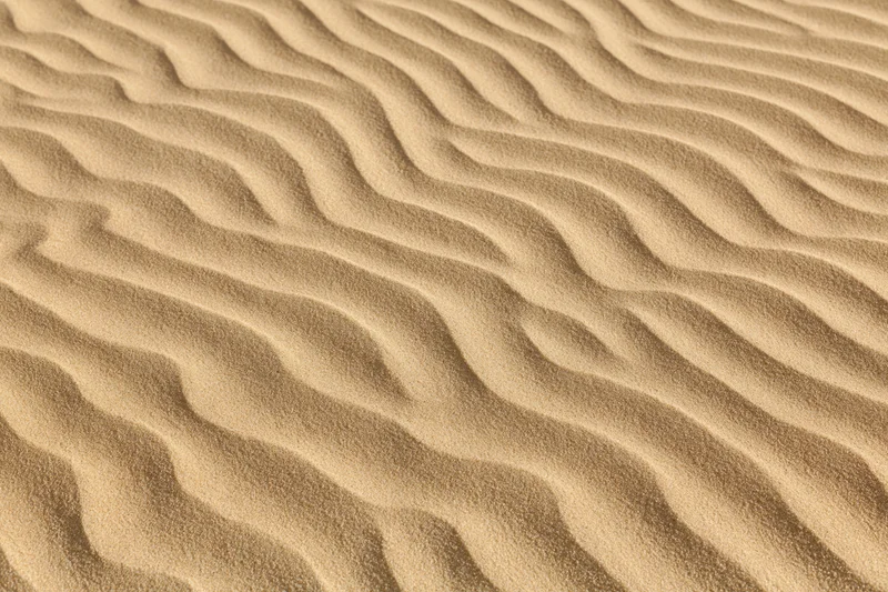 Close-up overhead view of rippled desert sand surface with natural wave patterns