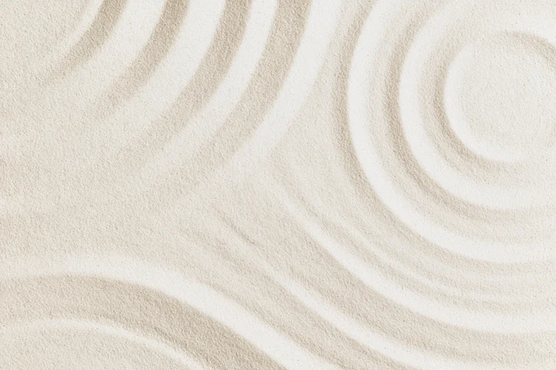 Raked sand forming circular patterns in a smooth beige texture