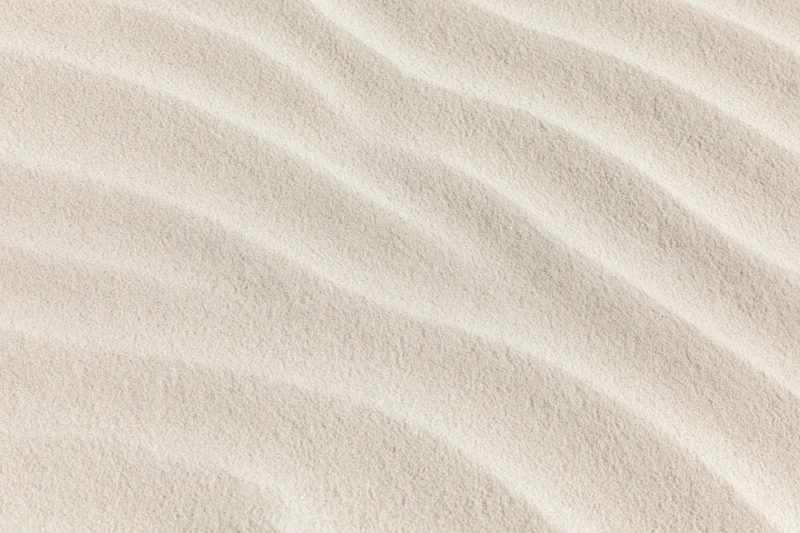 Close-up overhead view of smooth rippled beach sand surface