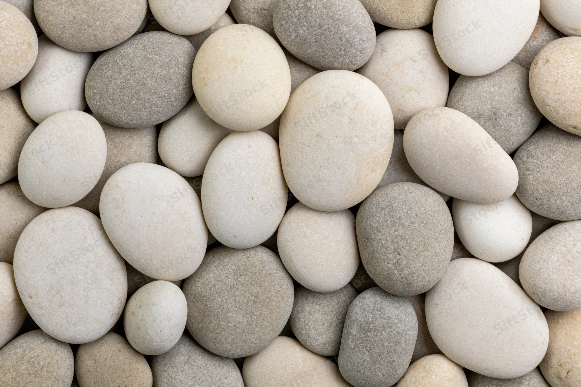 Smooth rounded pebbles arranged closely in a natural pattern filling the frame