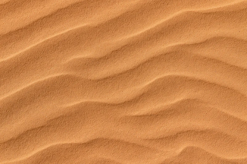 Close-up top-down view of rippled desert sand surface