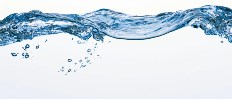 Flowing blue water surface with splashes and bubbles against white background