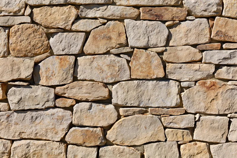 Dry-stacked stone wall filling the frame with irregular natural stones in earthy tones
