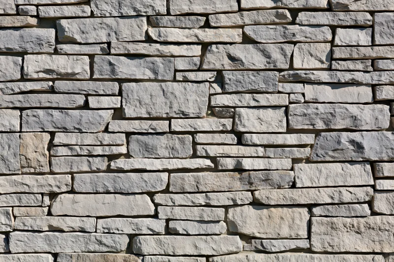 Dry-stacked stone wall filling the frame with irregularly cut stones arranged in horizontal layers