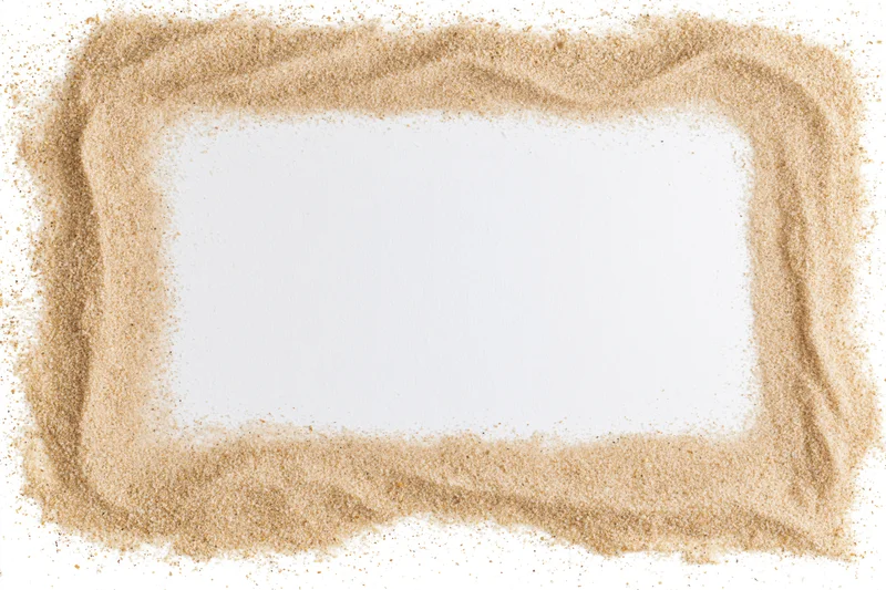 Dry beach sand arranged in a rectangular frame border on white background with central copyspace