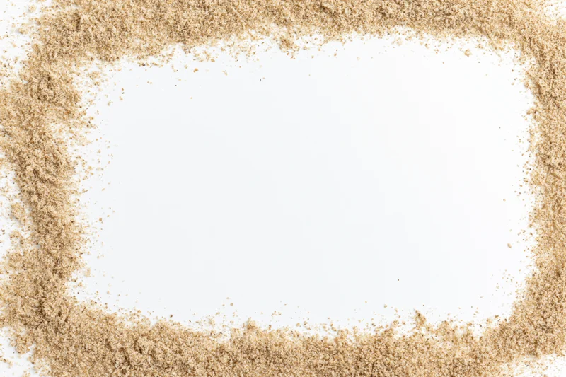 Beach sand arranged in a rectangular border around a white copyspace area
