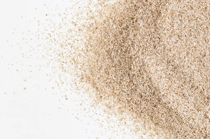 Fine dry sand scattered across a clean white surface