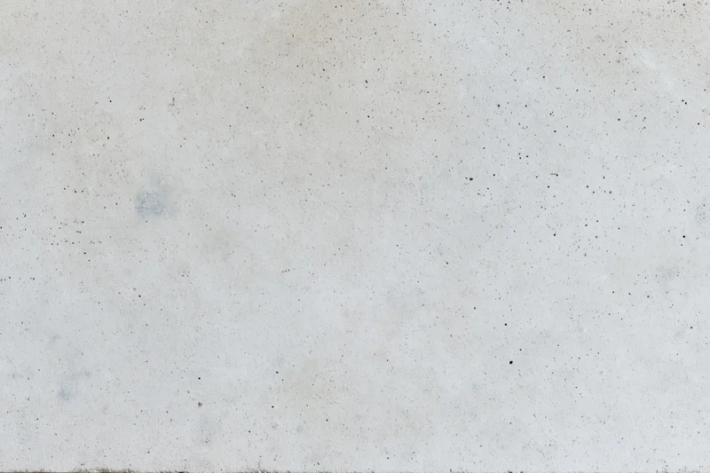Flat concrete surface with speckled texture and subtle stains, full-frame view