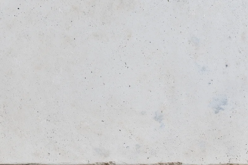 Flat concrete surface with speckled texture and minor stains filling the frame