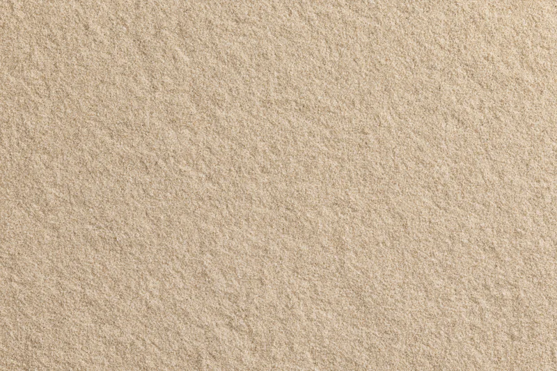 Flat dry sand surface filling the frame from overhead view