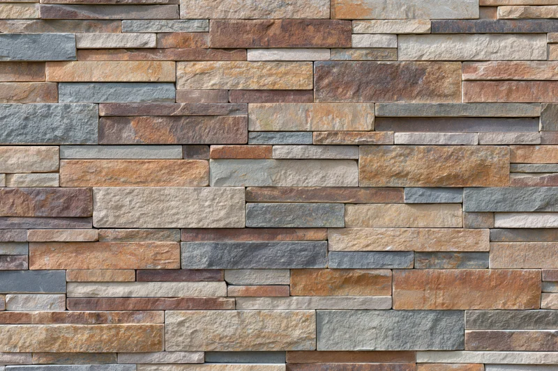 Stacked natural stone veneer tiles covering an exterior wall