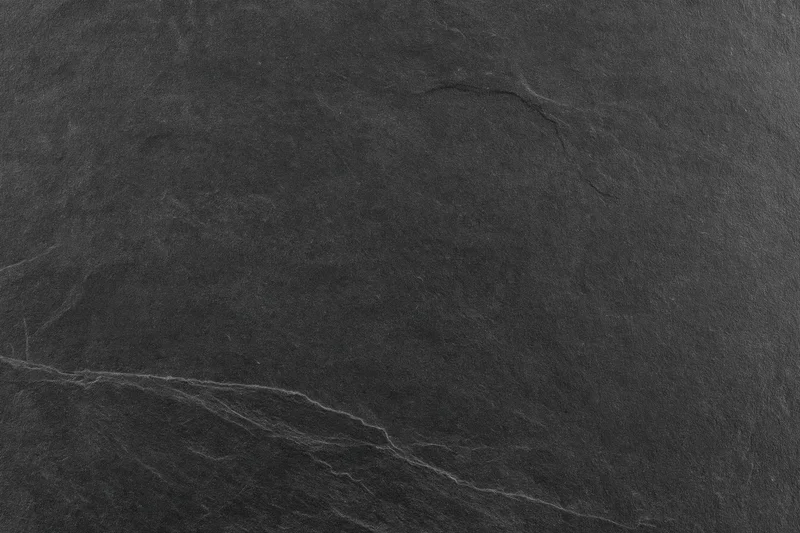 Close-up of dark slate stone surface with natural veins and texture