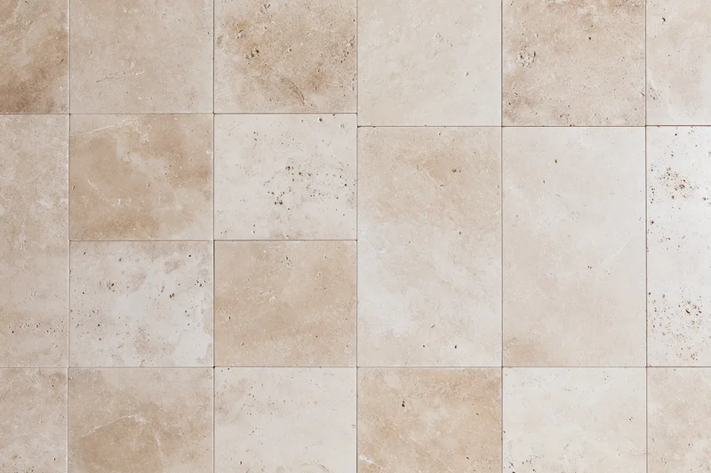 Travertine stone tiles arranged in a grid pattern for interior flooring or wall covering