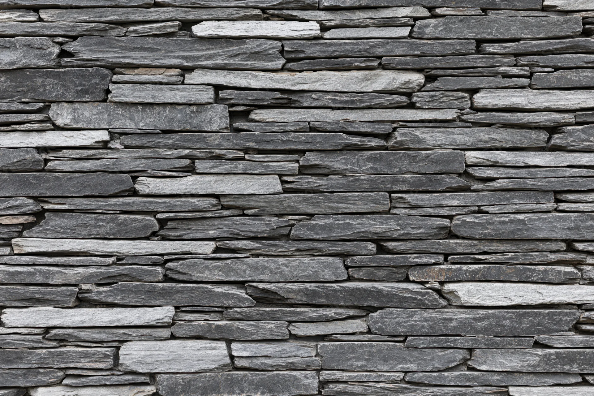 Flat stacked slate stone wall filling the frame horizontally