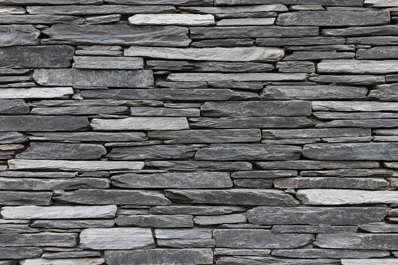 Flat stacked slate stone wall filling the frame horizontally