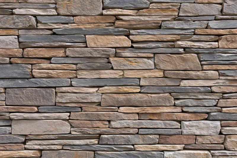 Stacked stone wall surface filling the frame with natural texture and horizontal layers