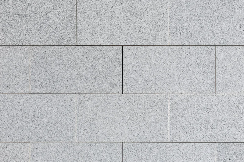 Light grey granite paving tiles arranged in a grid pattern for outdoor flooring