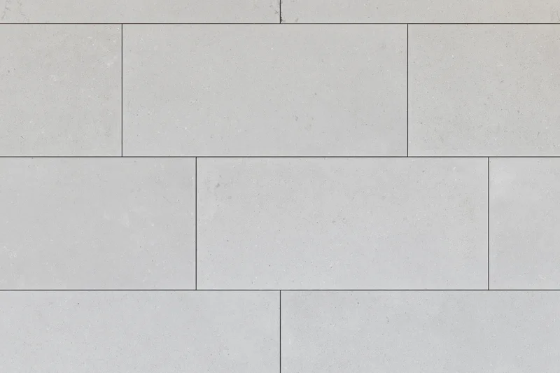 Large-format light grey concrete tiles arranged in a staggered pattern for flooring or pavement