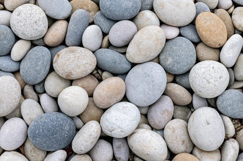 Smooth rounded river pebbles arranged in a dense overhead flat lay pattern