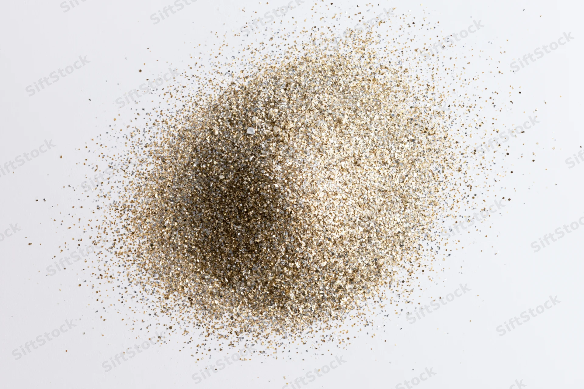 Pile of gold and silver glitter scattered on white surface