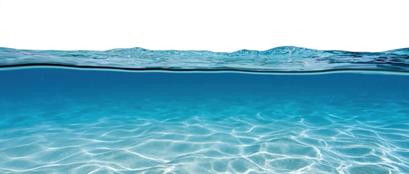 Split-level view of ocean surface and underwater sand with light patterns