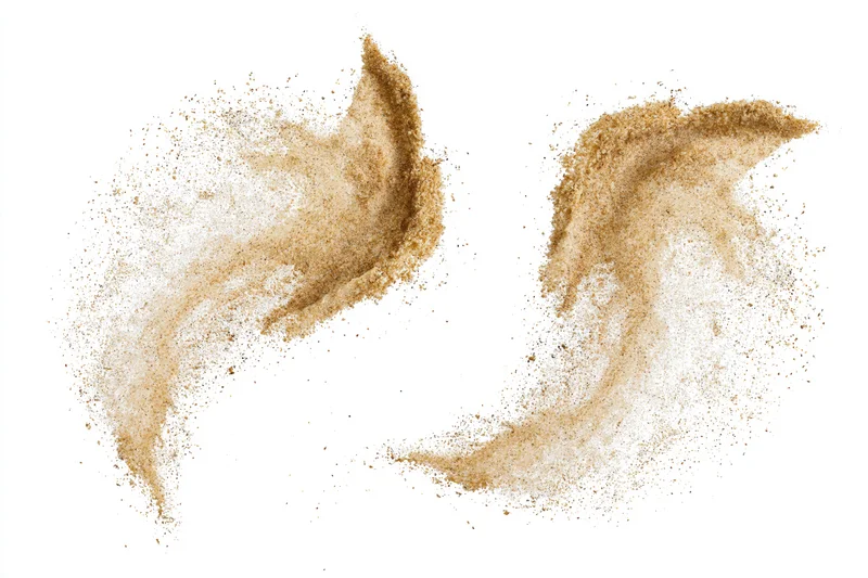 Two sand bursts suspended in mid-air against a white background
