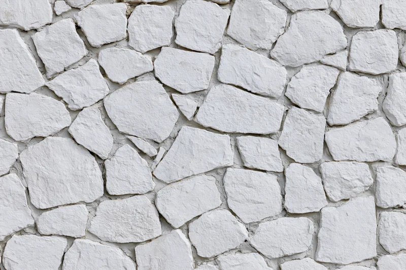 White painted irregular stone wall filling the frame
