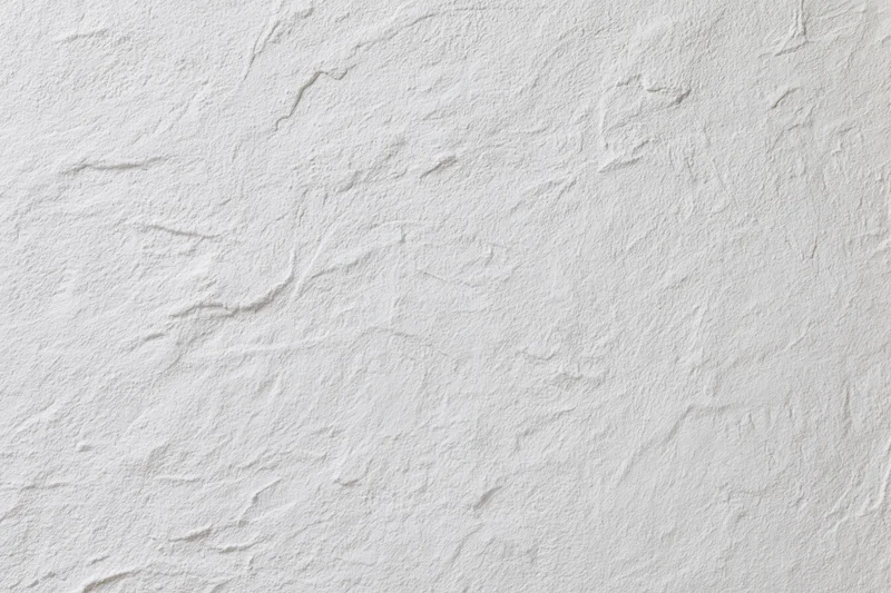 Textured white plaster wall surface filling the frame