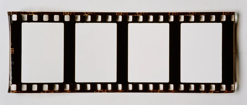 Horizontal 35mm film strip with four blank white frames on white background