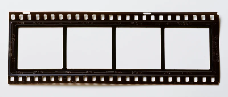 Horizontal 35mm film strip with four blank white exposed frames on white background