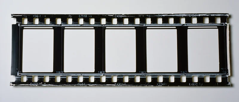 Horizontal strip of 35mm film negative with five empty frames on white background