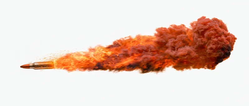 Bullet in motion trailing fire and smoke against white background