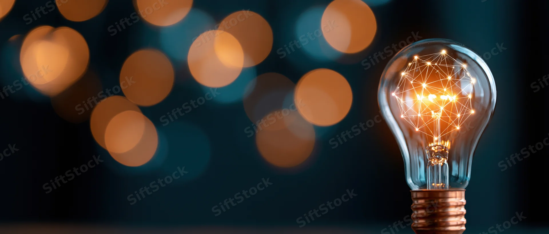 Glowing lightbulb with geometric wireframe network inside, against dark background with bokeh lights