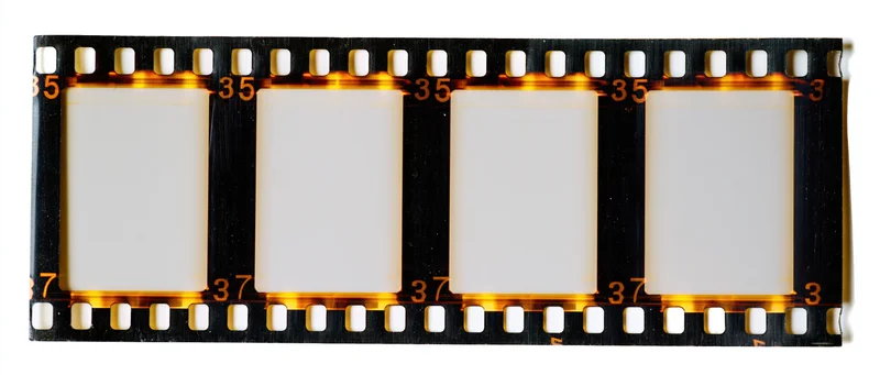 Strip of 35mm film negative with four blank frames and sprocket holes on white background