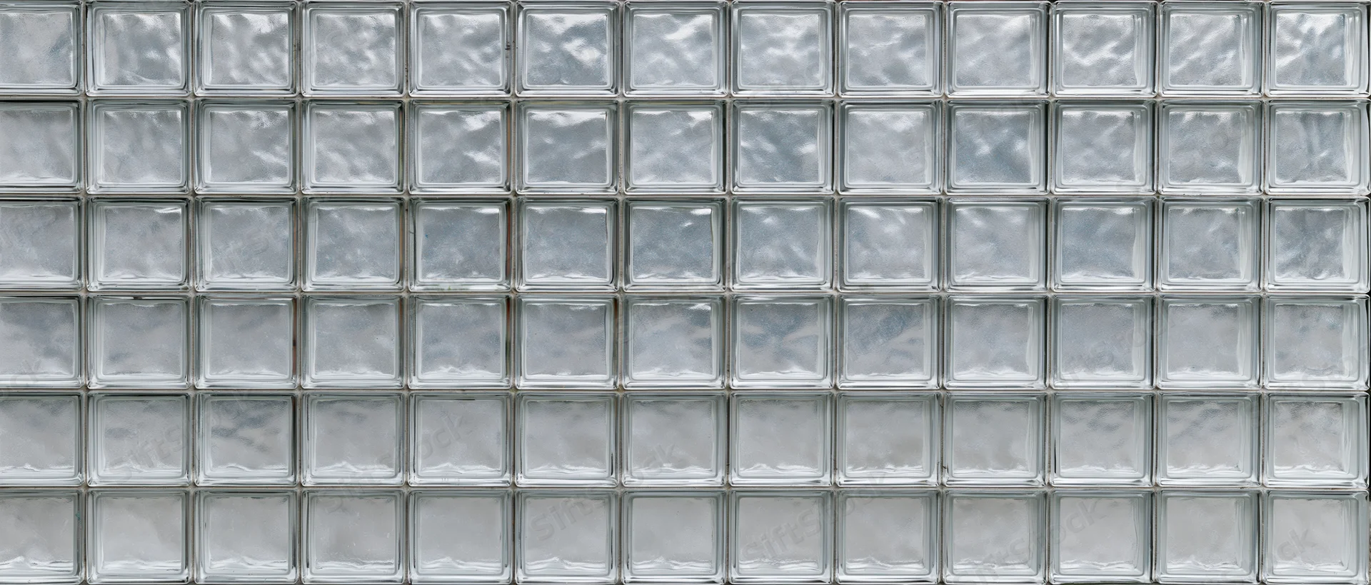 A wide flat wall made of small square glass blocks arranged in a grid pattern