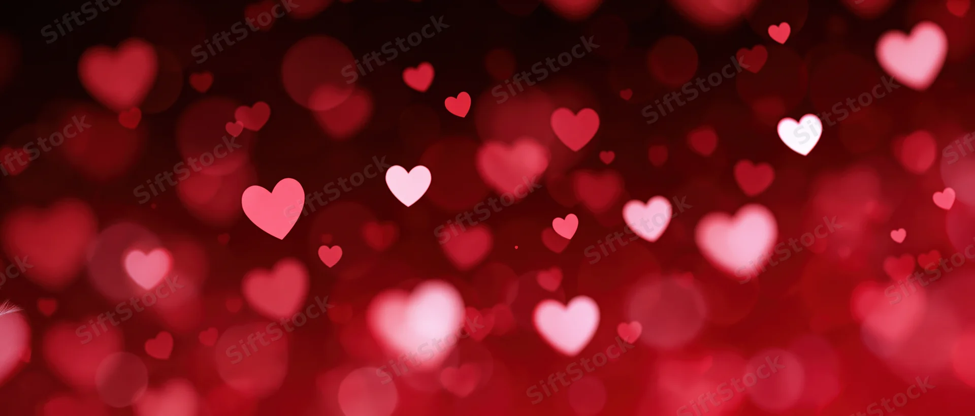 Abstract red bokeh background with glowing heart shapes for valentines day