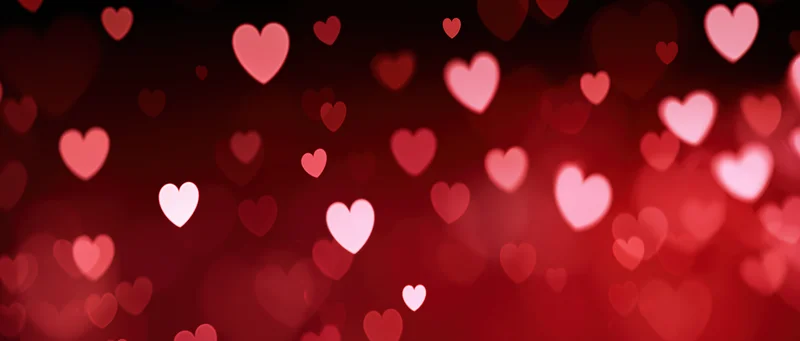 Glowing red hearts in soft bokeh against dark background