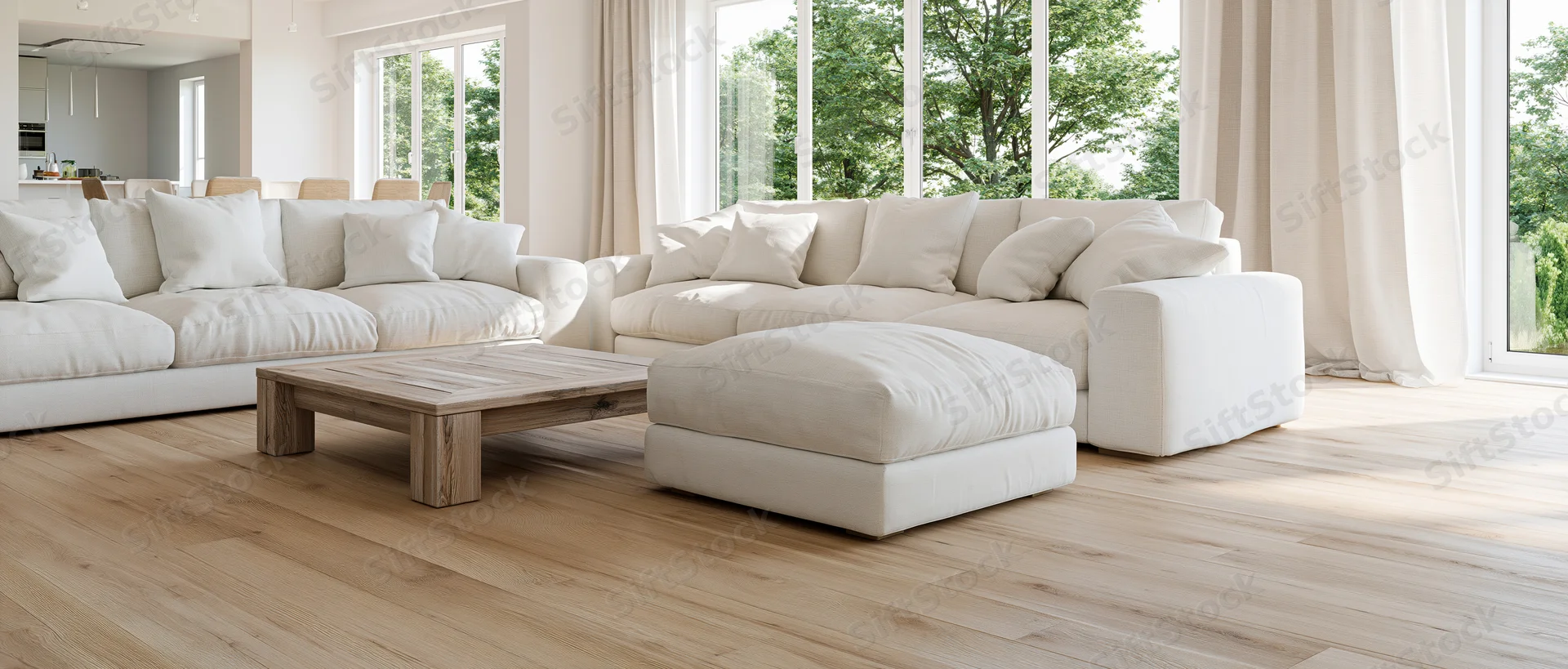 White linen sectional sofa with wooden coffee table and ottoman in bright contemporary living room with large windows and hardwood floor