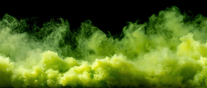 Neon green smoke and vapor clouds rising against a black background