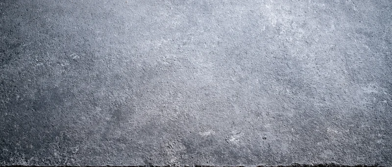 Close-up of a bare concrete wall surface with rough texture and gray tones