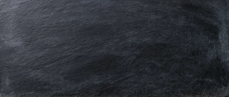Close-up of dark charcoal blackboard surface with textured stone-like finish